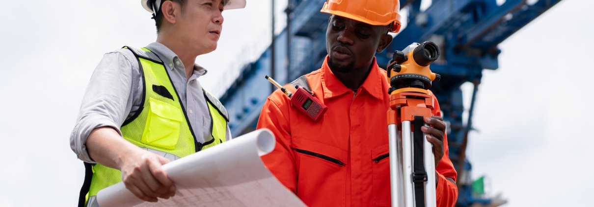 Civil engineers using a theodolite for a land survey