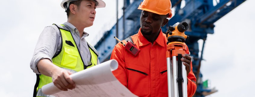 Civil engineers using a theodolite for a land survey